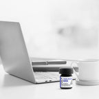Laptop with a bottle of 'Level' supplements on a white surface
