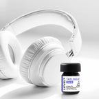 White headphones and a small bottle labeled 'LEVEL CALM' on a light gray background
